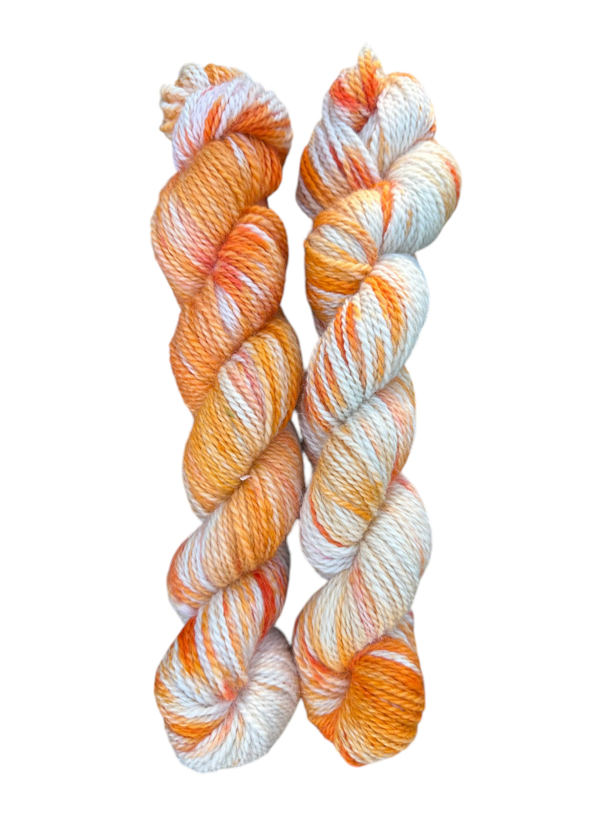 Two skeins of Oak Crest Alpacas and More hand-dyed variegated orange and white 100% American alpaca worsted yarn.
