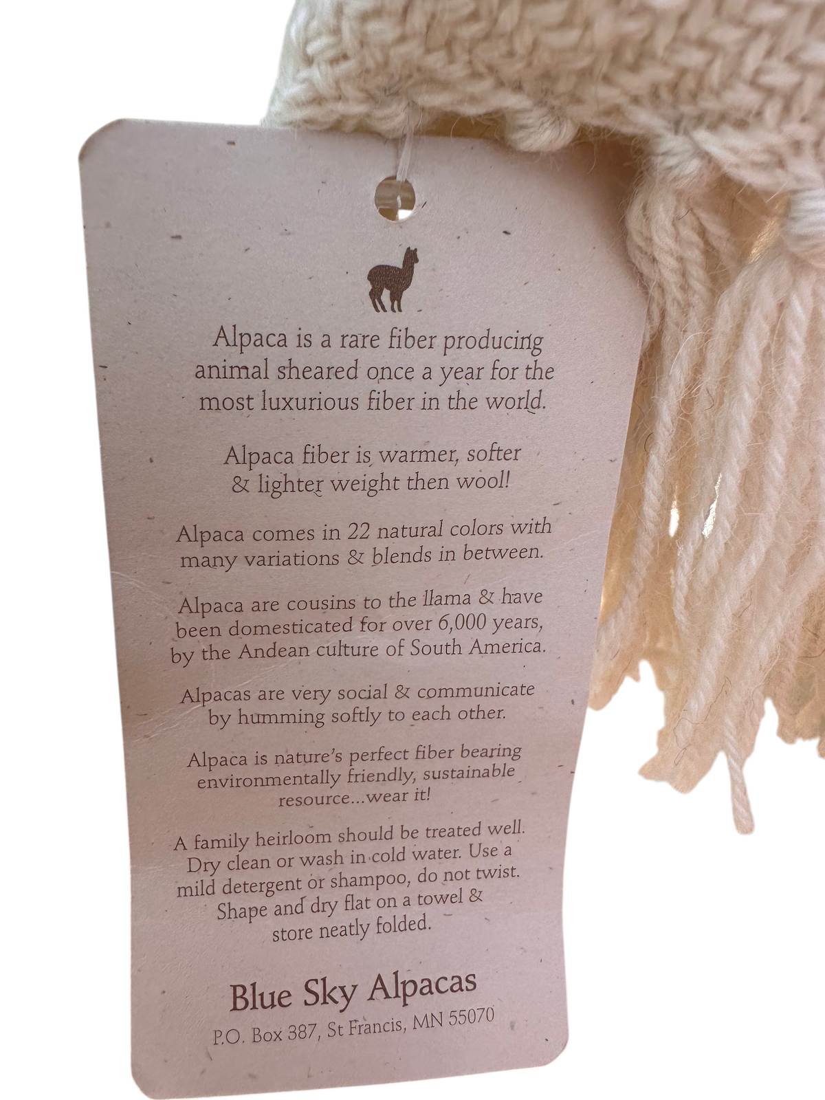Oak Crest Alpacas and More woven baby alpaca scarf with product information tag in natural white