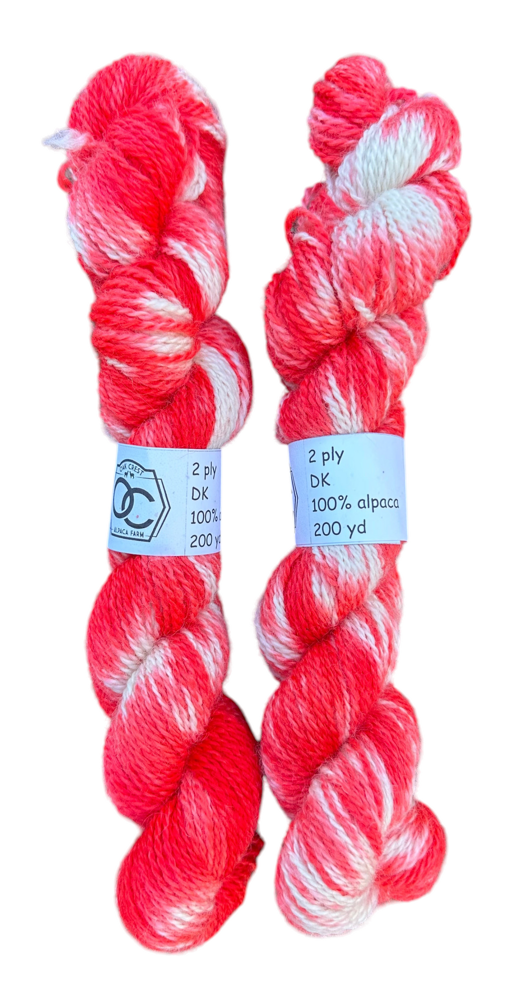 Two skeins of hand-dyed red and white variegated Oak Crest Alpacas and More 100% American alpaca DK weight yarn.