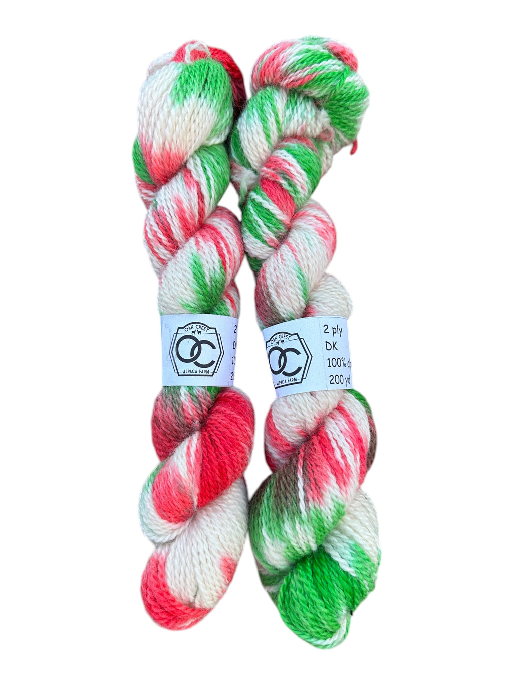 Oak Crest Alpacas and More hand dyed DK weight 100% alpaca yarn skeins in festive red, green, and white colors.