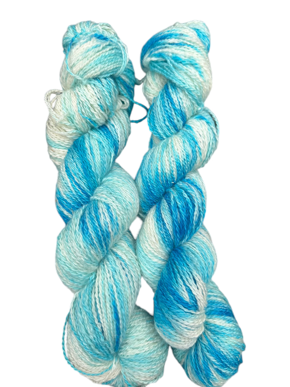 Two skeins of Oak Crest Alpacas and More hand-dyed fingering weight alpaca yarn in variegated blue and white tones.