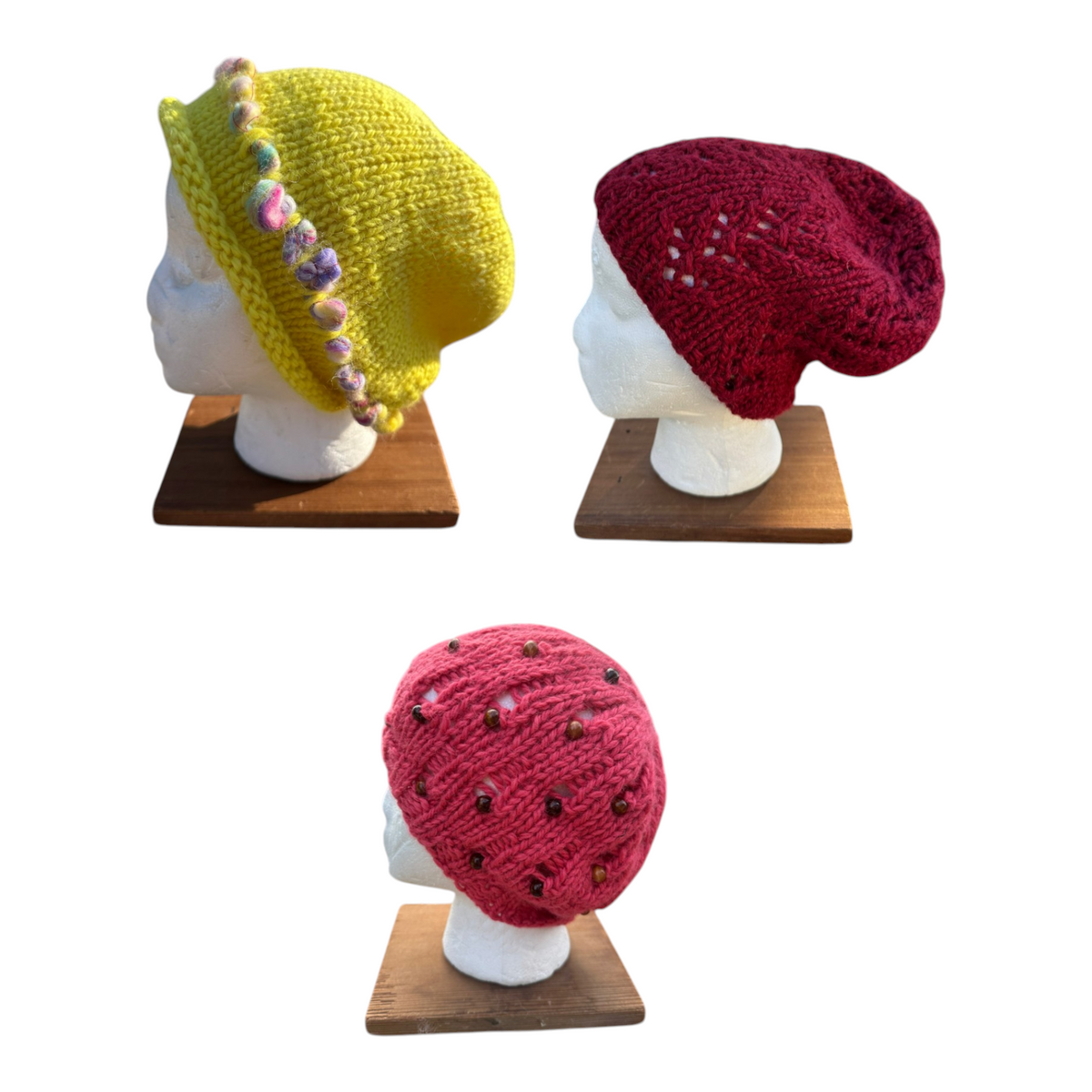 Oak Crest Alpacas and More hand knit chunky alpaca winter hats in yellow, cranberry red, and pink coral on mannequins.