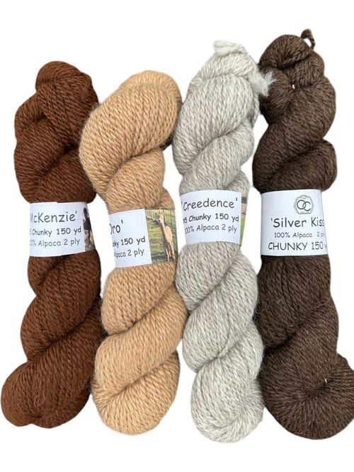 Oak Crest Alpacas and More chunky 2-ply alpaca yarn skeins in natural brown, fawn, silver gray, and black shades.