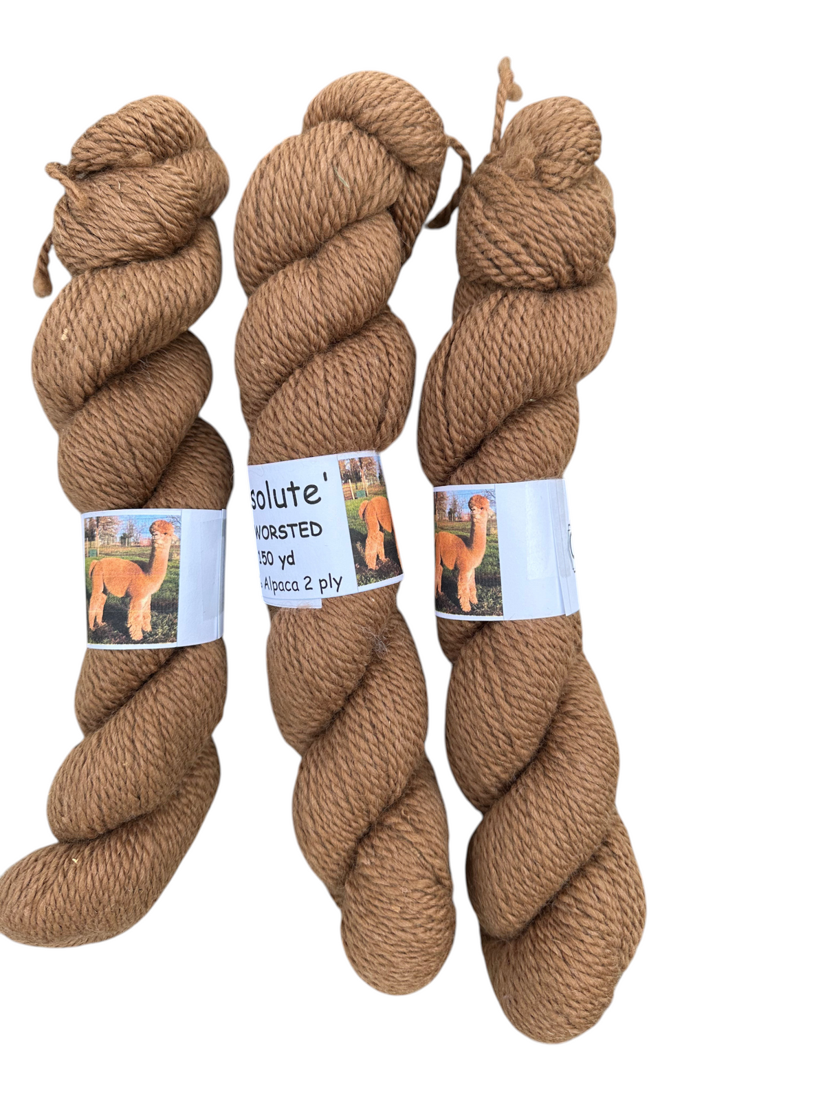 Oak Crest Alpacas and More 2 ply worsted alpaca yarn skeins in natural medium fawn color with product labels.