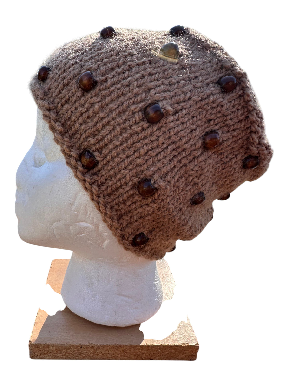 Oak Crest Alpacas and More hand-knit fawn alpaca yarn beanie decorated with brown wooden beads on a mannequin head.