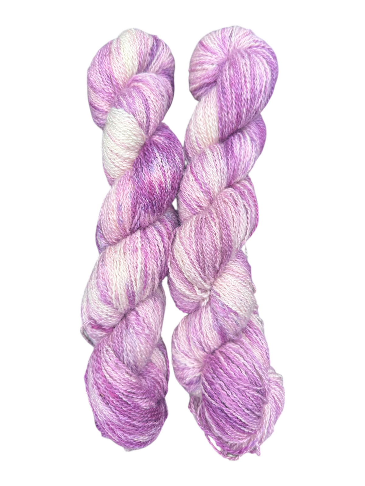 Two skeins of Oak Crest Alpacas and More hand-dyed fingering weight alpaca yarn in variegated purple and white.