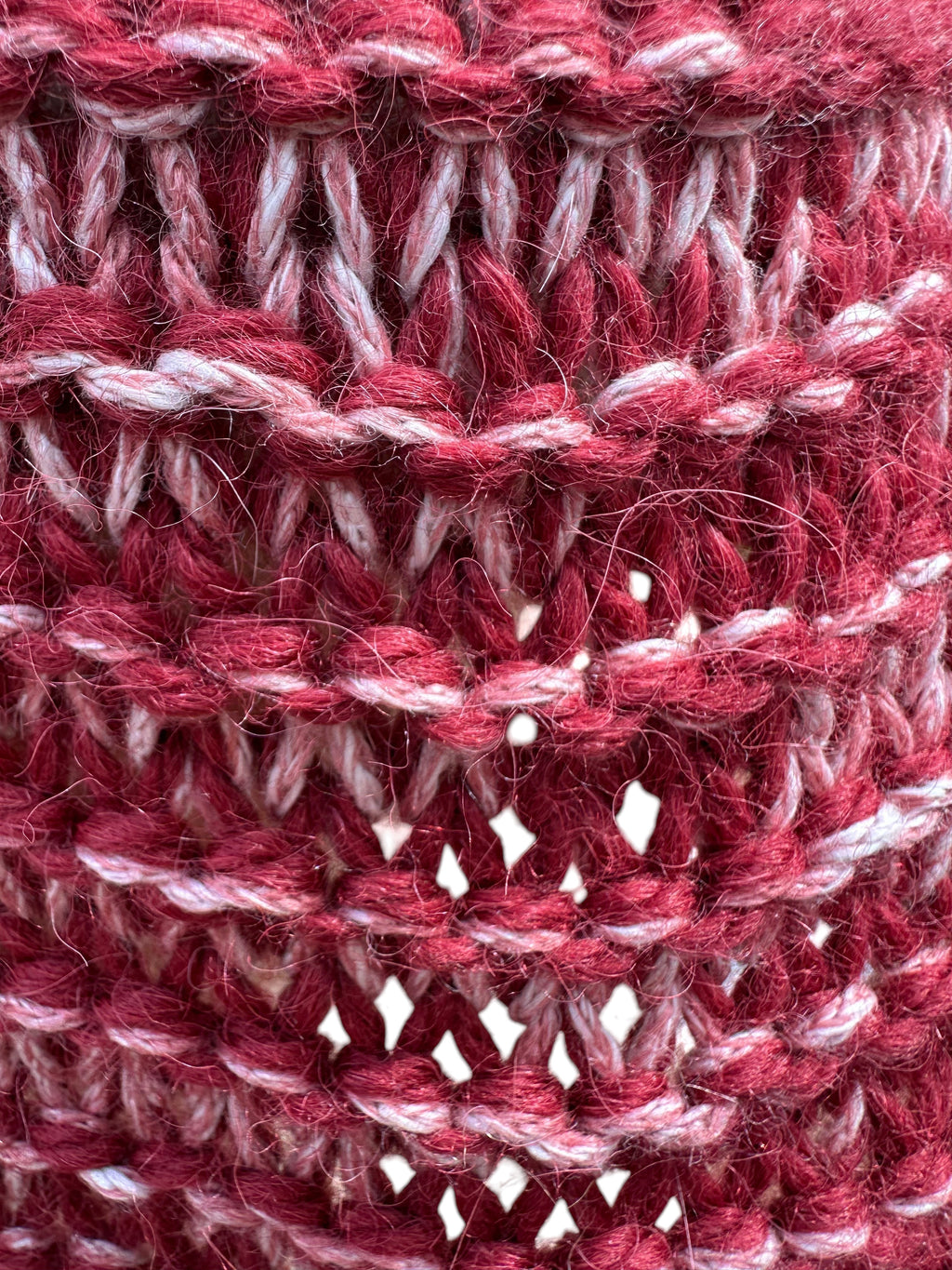 Close-up of a hand-knit Oak Crest Alpacas and More scarf featuring a marled red and white alpaca-cotton blend texture.