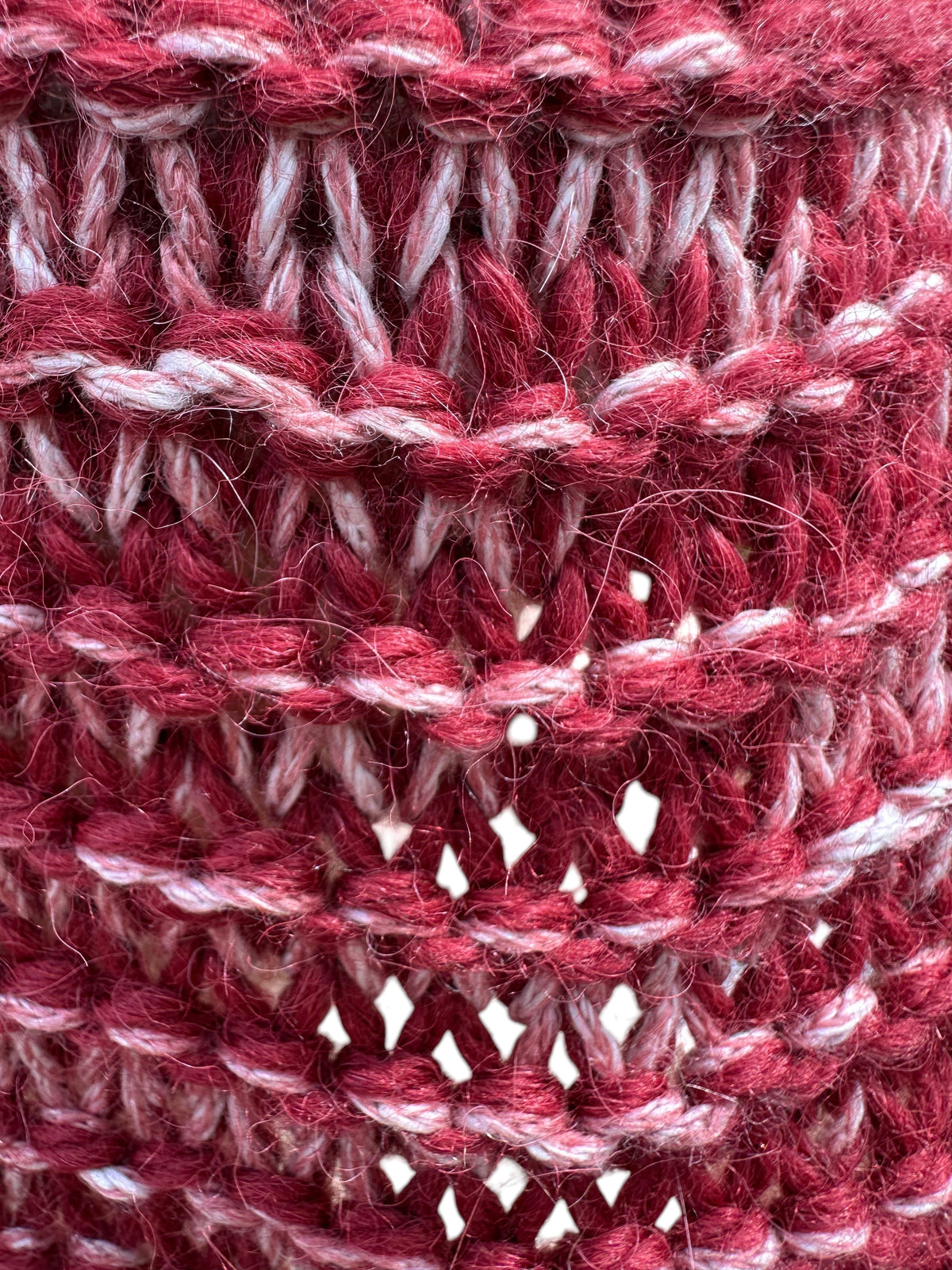 Close-up of a hand-knit Oak Crest Alpacas and More scarf featuring a marled red and white alpaca-cotton blend texture.