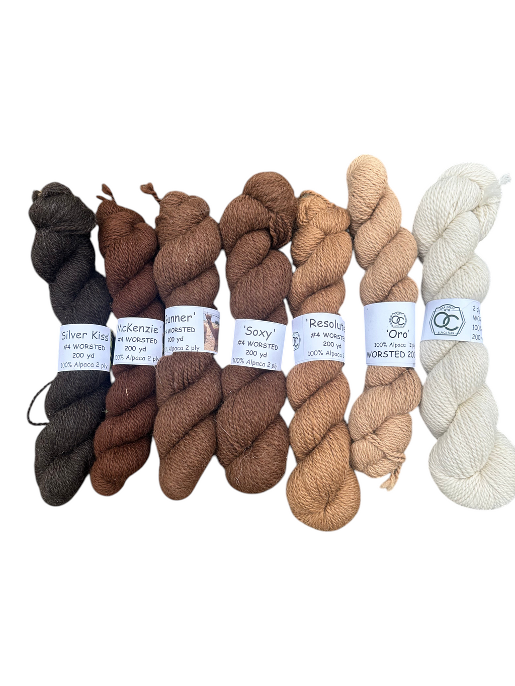 Oak Crest Alpacas and More natural 100% USA alpaca worsted yarn skeins in various shades of brown and fawn.
