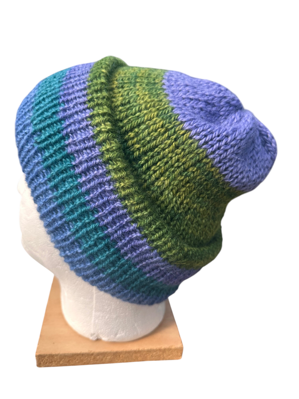 Oak Crest Alpacas and More reversible double knit alpaca hat in striped purple, teal, and green on a mannequin head
