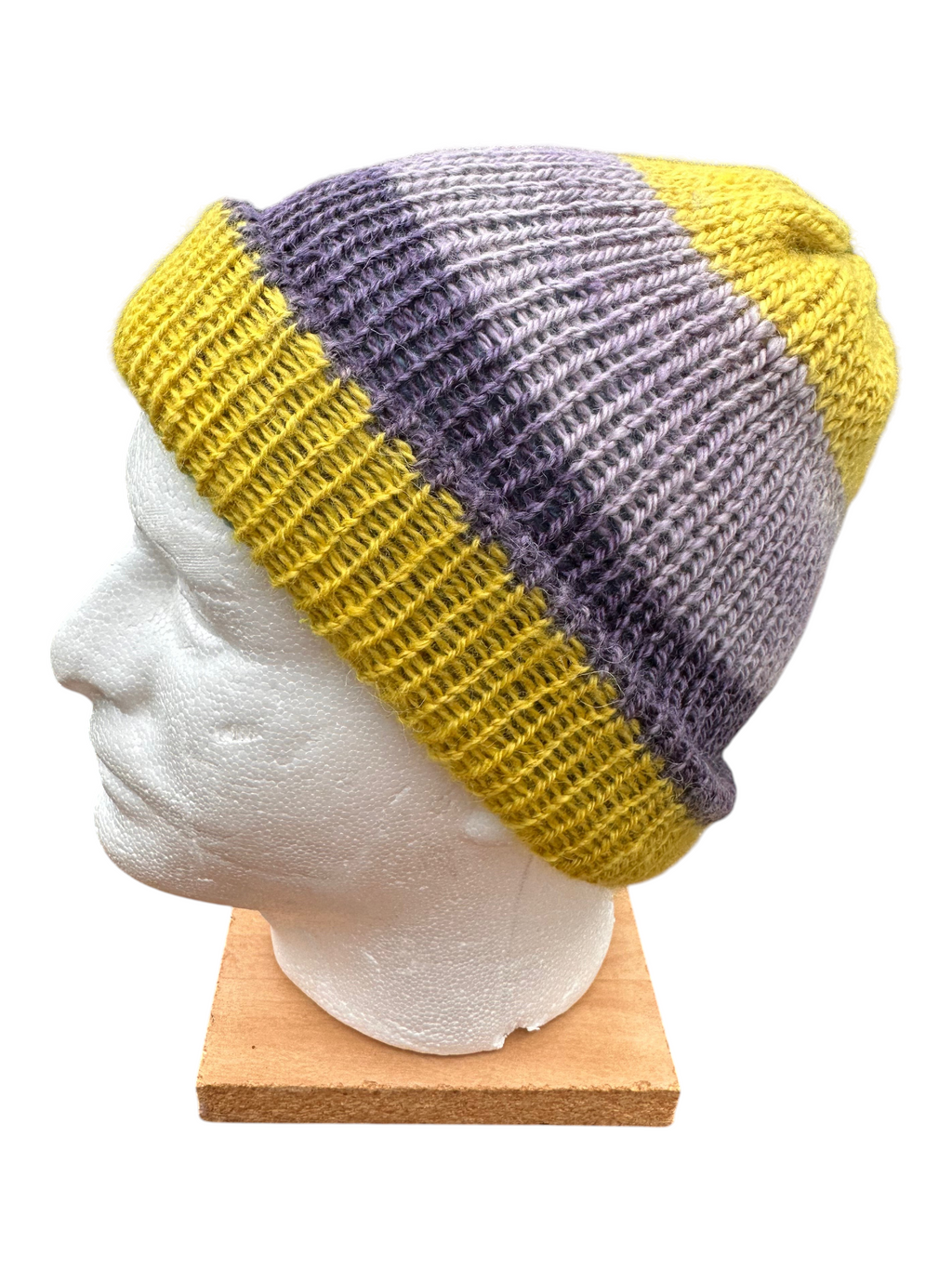 Oak Crest Alpacas and More reversible double knit alpaca hat in purple, yellow, blue, and pink on a mannequin head.