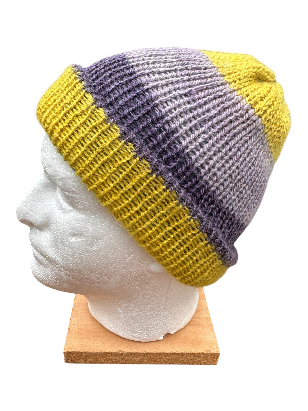 Oak Crest Alpacas and More reversible double knit alpaca hat in purple, yellow, blue, and pink on a mannequin head.