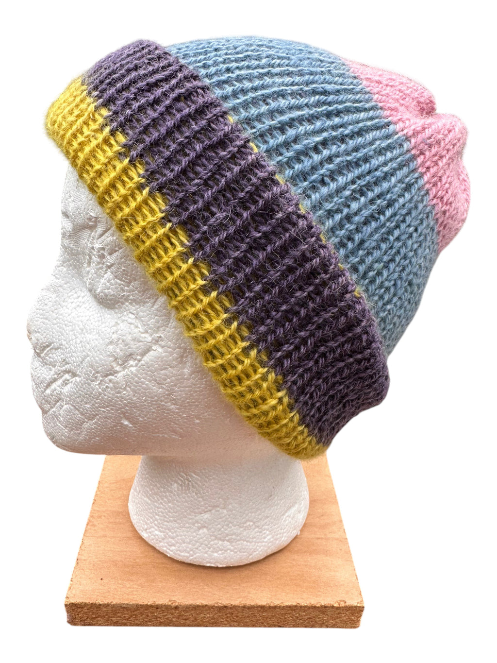 Oak Crest Alpacas and More reversible double knit alpaca hat in purple, yellow, blue, and pink on a mannequin head.